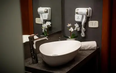 a bathroom with a white sink on a counter at SuiteSicily Rooms Palermo in Altavilla Milicia
