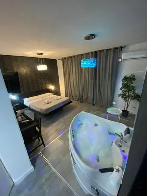 a room with a bath tub and a bedroom at SuiteSicily Rooms Palermo in Altavilla Milicia