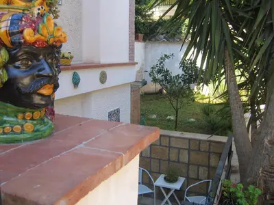a statue of a face with fruit on a table at Appartamento Vivaldi in Mondello