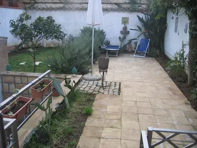 a patio with a table and chairs and an umbrella at Appartamento Vivaldi in Mondello