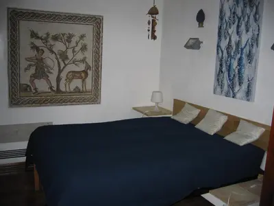 a bedroom with a blue bed and a painting on the wall at Appartamento Vivaldi in Mondello