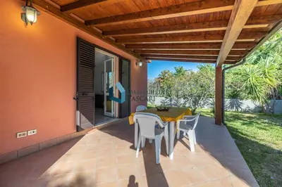 a patio with a table and chairs on it at Villa Siragusa con piscina condominiale in Campofelice di Roccella