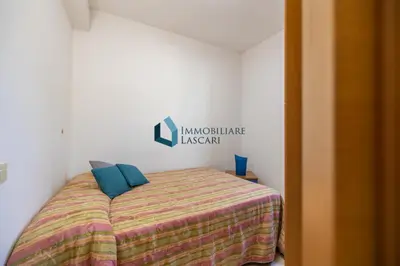 a bed with two blue pillows in a room at Villa Siragusa con piscina condominiale in Campofelice di Roccella