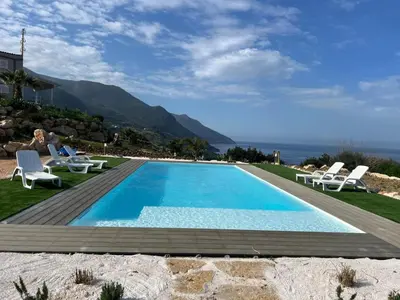 a swimming pool with the ocean in the background at La Finestra sul Mare dello Zingaro in Scopello