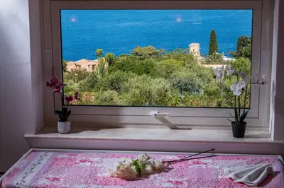 a bedroom with a window with a view of the ocean at La Finestra sul Mare dello Zingaro in Scopello