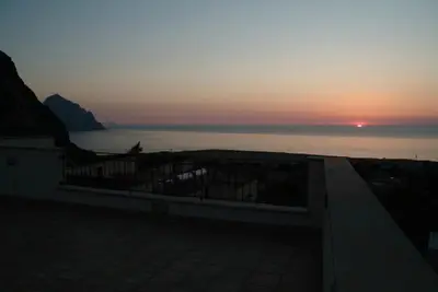 a sunset over the water with a fence and the ocean at Torre Salina in Macari