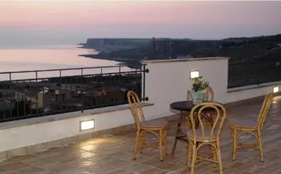 a table and chairs on a balcony with a view at Torre Salina in Macari