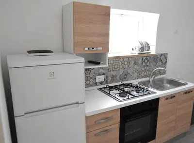 a kitchen with a white refrigerator and a sink at Le Volte - Locazione Turistica in Terrasini