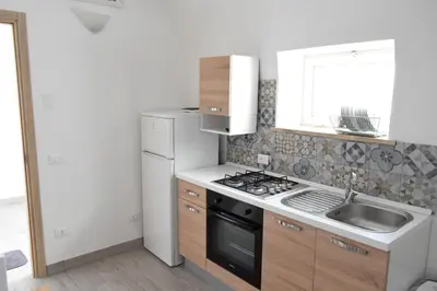 a kitchen with a sink and a stove top oven at Le Volte - Locazione Turistica in Terrasini