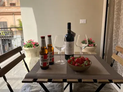 a table with two bottles of wine and a bowl of strawberries at Caporama in Terrasini