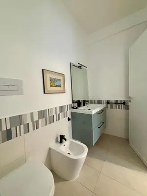 a bathroom with a sink and a toilet and a mirror at Casa in villa vista mare in Palermo
