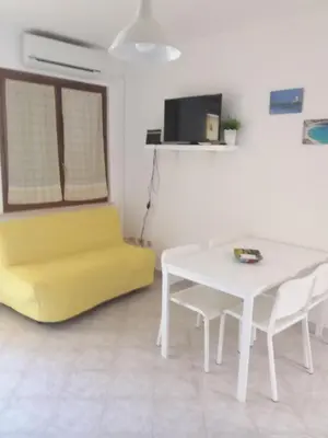 a living room with a yellow couch and a table at fabrizio e caterina in San Vito lo Capo