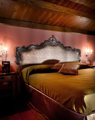 a bedroom with a large bed with a large headboard at Il Baglio Della Luna Relais by Le Dhome Sicily in Balestrate