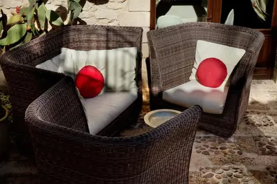 two wicker chairs with red pillows on them at Il Baglio Della Luna Relais by Le Dhome Sicily in Balestrate