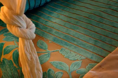 a close up of a bed with green and orange carpet at Il Baglio Della Luna Relais by Le Dhome Sicily in Balestrate