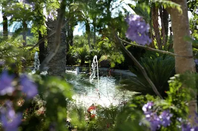 a garden with a fountain in the middle of a pond at Il Baglio Della Luna Relais by Le Dhome Sicily in Balestrate