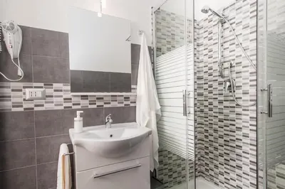 a bathroom with a sink and a glass shower at Casa Genna in Isola delle Femmine