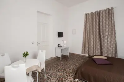 a bedroom with a bed and a table and chairs at Casa Genna in Isola delle Femmine