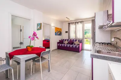 a kitchen and living room with a table and a couch at Villa Sara in Lascari