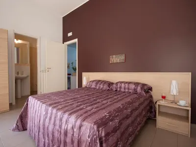 a bedroom with a large bed with a purple bedspread at Vado Al Massimo in Palermo