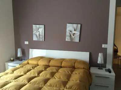 a bed in a bedroom with three pictures on the wall at Vado Al Massimo in Palermo