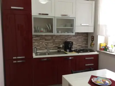 a kitchen with red cabinets and a sink at Vado Al Massimo in Palermo