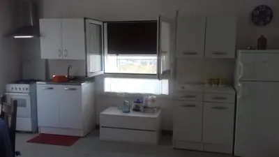 a kitchen with white cabinets and a large window at Principessa Jolanda in Mondello