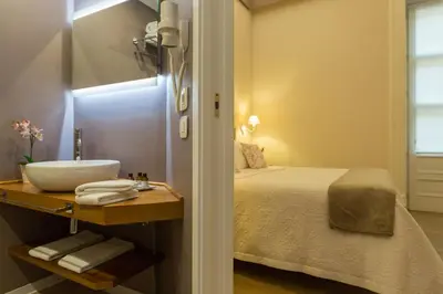 a bathroom with a sink and a bed in a room at Bellaroto Suite & Spa - Charming Boutique Rooms in Palermo
