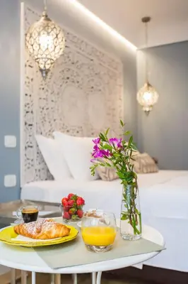 a breakfast table with a plate of food and a bed at Bellaroto Suite & Spa - Charming Boutique Rooms in Palermo