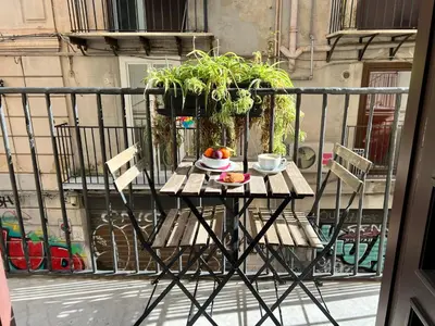 a table with a bowl of fruit on a balcony at Bellaroto Suite & Spa - Charming Boutique Rooms in Palermo
