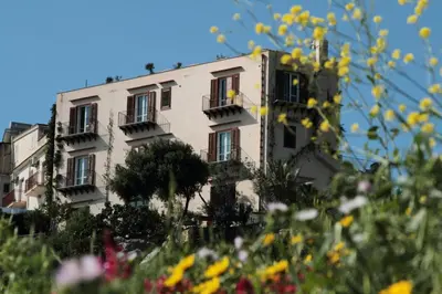 a building in front of a field of flowers at Torre Bennistra in Scopello