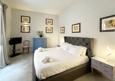 a bedroom with a bed and a desk and a television at Solemar Sicilia - Valuan Luxury Home in Palermo