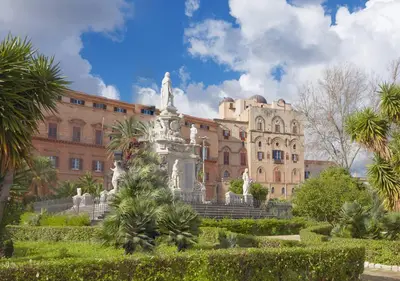 a building with a statue in front of a garden at Solemar Sicilia - Valuan Luxury Home in Palermo