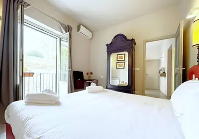 a bedroom with a white bed and a large window at Solemar Sicilia - Valuan Luxury Home in Palermo