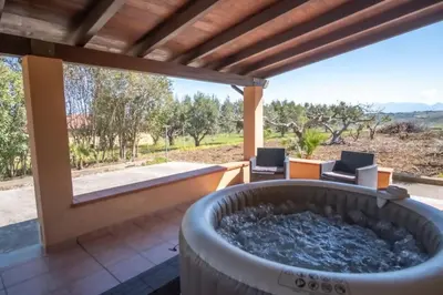 a large hot tub on a patio with two chairs at Villa Indipendente Jacuzzi Giardino Clima WiFi in Castellammare del Golfo