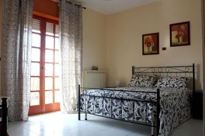 a bedroom with a bed and a sliding glass door at La casa di Bia in Corleone