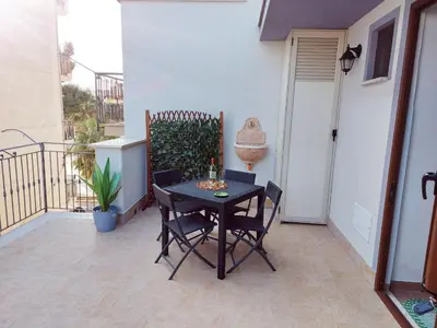a patio with a table and chairs on a balcony at Terrazza New Homes in Castellammare del Golfo