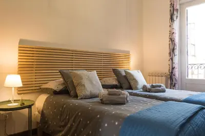 a bedroom with a bed with a lamp on a side table at Large terrace apartment near Politeama in Palermo