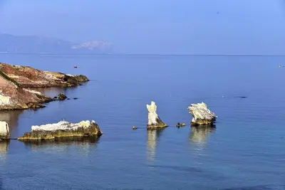a large body of water with rocks and a beach at Apartment in the center in Terrasini