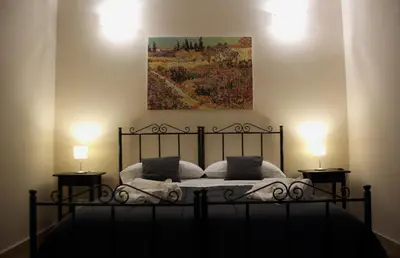 a bedroom with a bed with a painting on the wall at Mantegna Rooms in Palermo