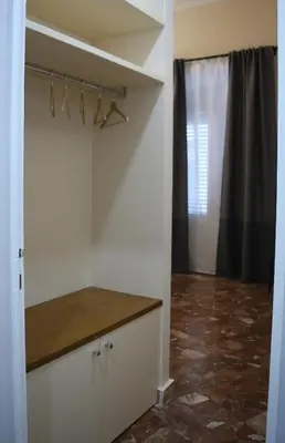a kitchen with white walls and a counter with hangers at Mantegna Rooms in Palermo