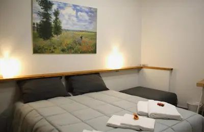 a bed in a room with a painting on the wall at Mantegna Rooms in Palermo