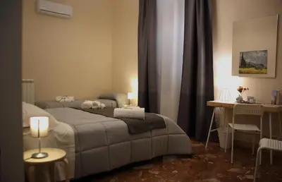 a bedroom with a bed and a table with two candles at Mantegna Rooms in Palermo