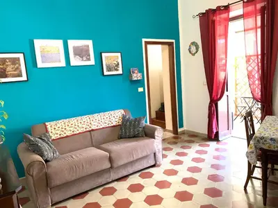a living room with a couch and a blue wall at Casa Arenella appartamento con parcheggio privato in Palermo