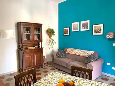 a living room with a couch and a blue wall at Casa Arenella appartamento con parcheggio privato in Palermo