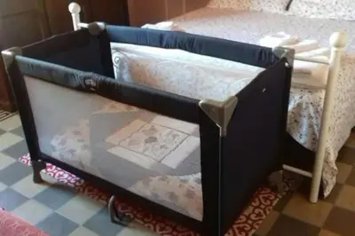 a black crib with a bed in a room at Casa Arenella appartamento con parcheggio privato in Palermo