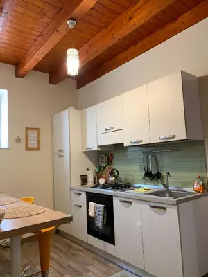 a kitchen with white cabinets and a wooden ceiling at Casa Arenella appartamento con parcheggio privato in Palermo