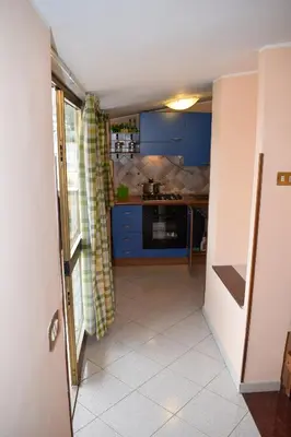 a kitchen with blue cabinets and a tiled floor at Casa Gagà in Sferracavallo