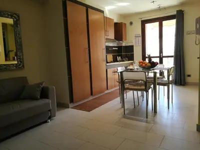 a living room with a table and chairs and a kitchen at Casa Valeria in Balestrate