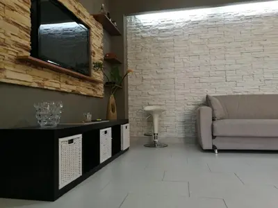 a living room with a couch and a brick wall at Casa Valeria in Balestrate